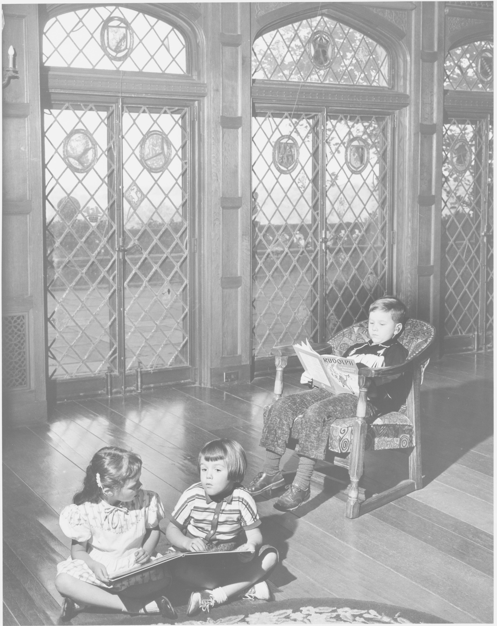 The Manor's signature Connick stained glass diamond-paned windows, photographed in the 1950s with Deaf students reading nearby